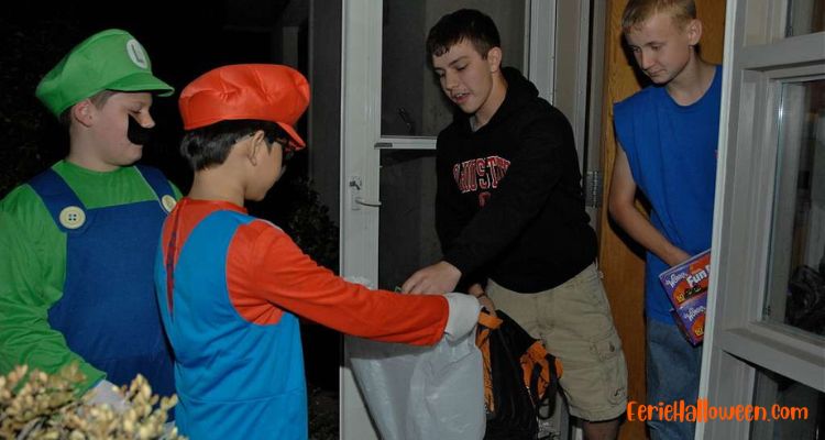 teens hand out halloween candy